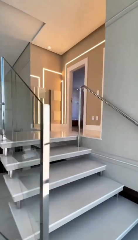 Escada com guarda-corpo de vidro e estrutura em aço inox